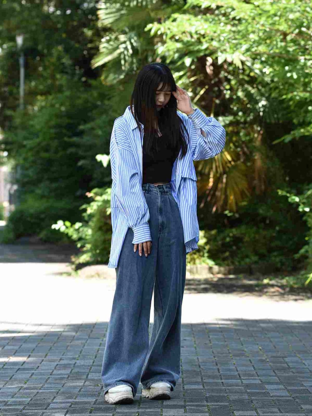 ブルー系のデニムパンツ、ブルー系のシャツ/ブラウス、シルバー系のバングル/リストバンドを着用したレディースの夏コーディネートの1枚目の写真