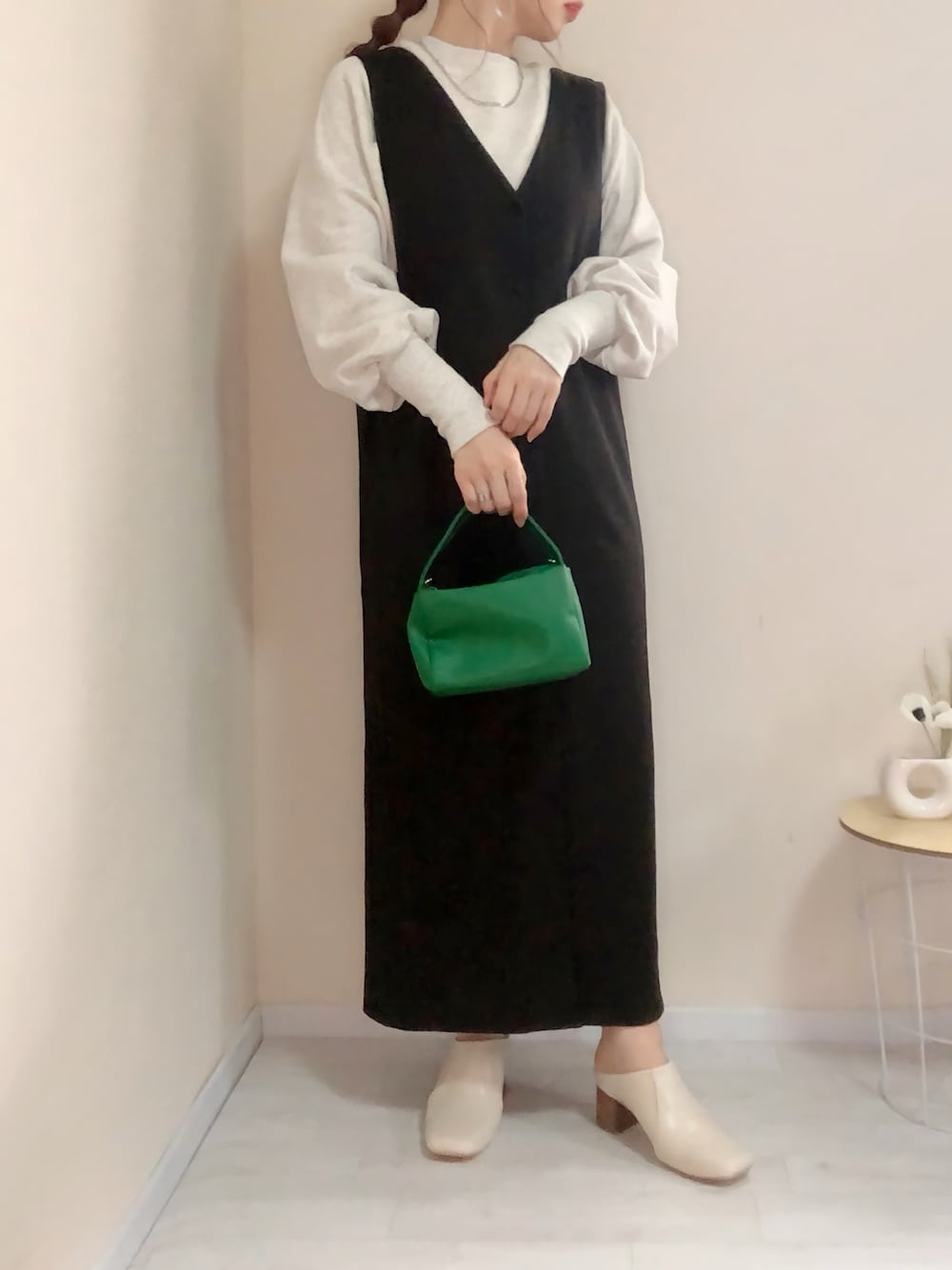 ベージュ系のスウェット、ブラック系のジャンパースカート、ホワイト系のその他シューズを着用したレディースの春コーディネートの1枚目の写真