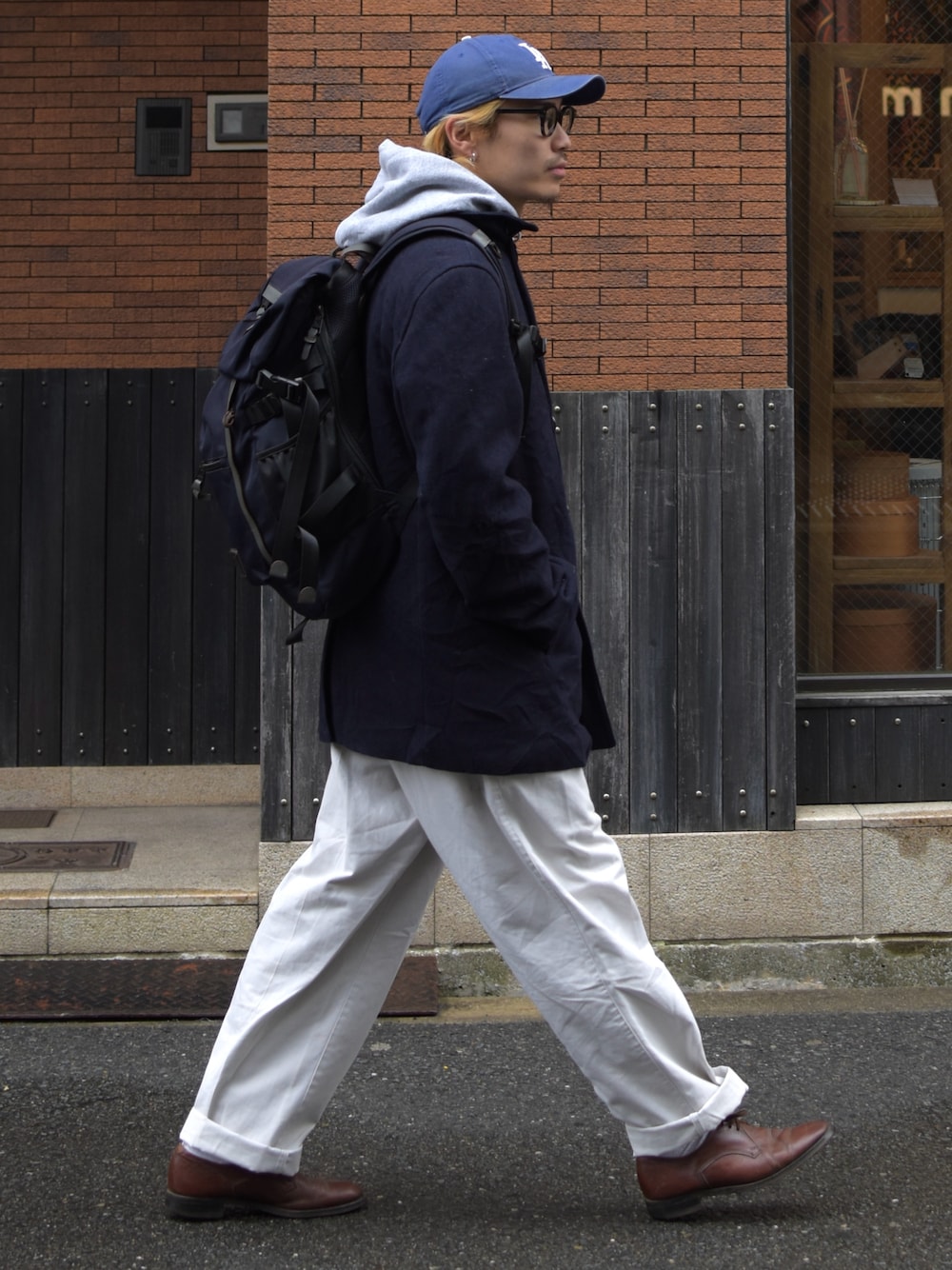 ホワイト系のチノパンツ、ブルー系のキャップを着用したメンズの秋コーディネートの1枚目の写真