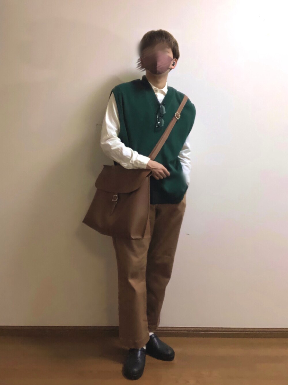 グリーン系のベスト、ホワイト系のシャツ/ブラウス、ブラウン系のバックパック/リュックを着用したメンズの春コーディネートの1枚目の写真