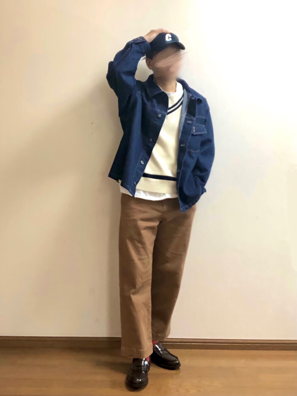 ブルー系のデニムジャケット、ホワイト系のベスト、ブラウン系のチノパンツを着用したメンズの春コーディネートの1枚目の写真