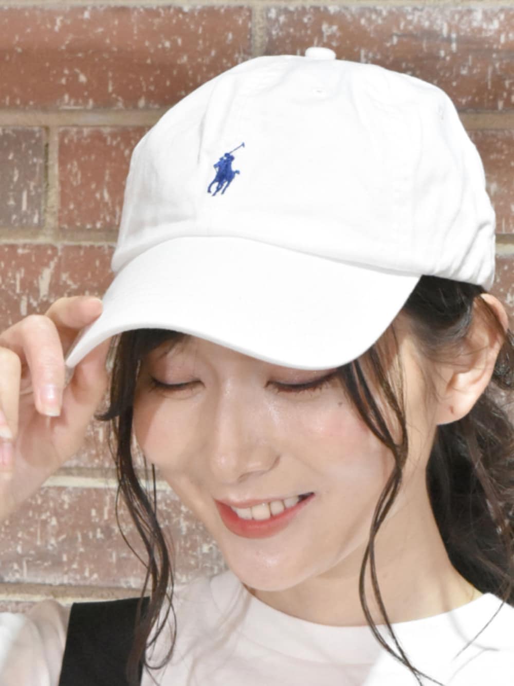ホワイト系のキャップを着用したレディースの夏コーディネートの1枚目の写真