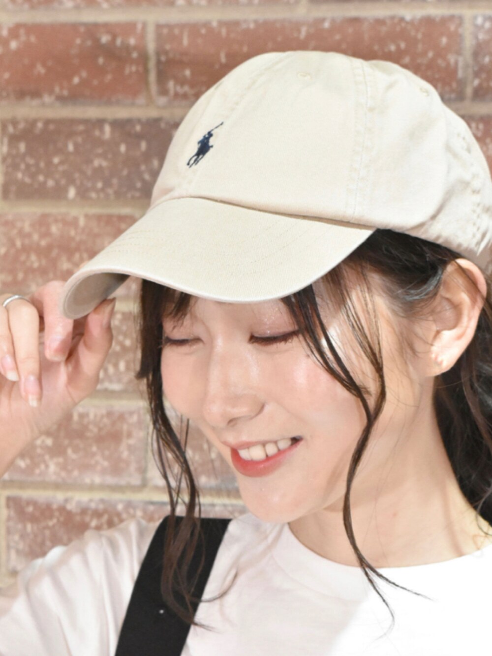 ベージュ系のキャップを着用したレディースの夏コーディネートの1枚目の写真