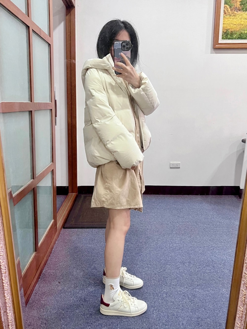 ホワイト系のスニーカー、ホワイト系のダウンジャケット/コート、ベージュ系のワンピース/ドレスを着用したレディースの冬コーディネートの1枚目の写真