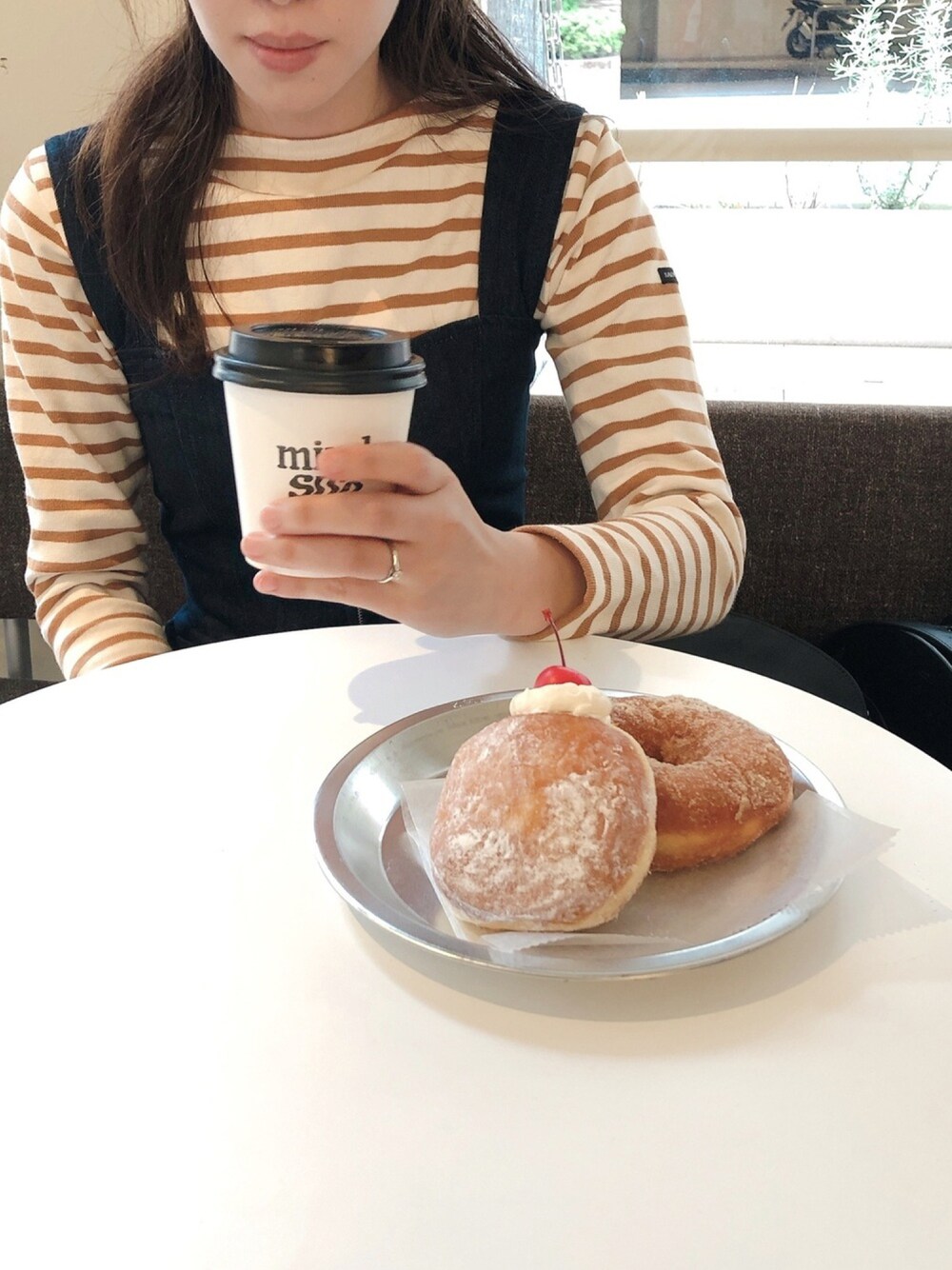 ブラウン系のTシャツ/カットソー、ブルー系のワンピースを着用したレディースの春コーディネートの1枚目の写真