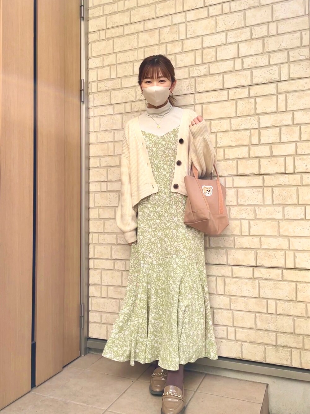 グリーン系のワンピース、ベージュ系のトートバッグ、ホワイト系のカーディガン/ボレロを着用したレディースの春コーディネートの1枚目の写真