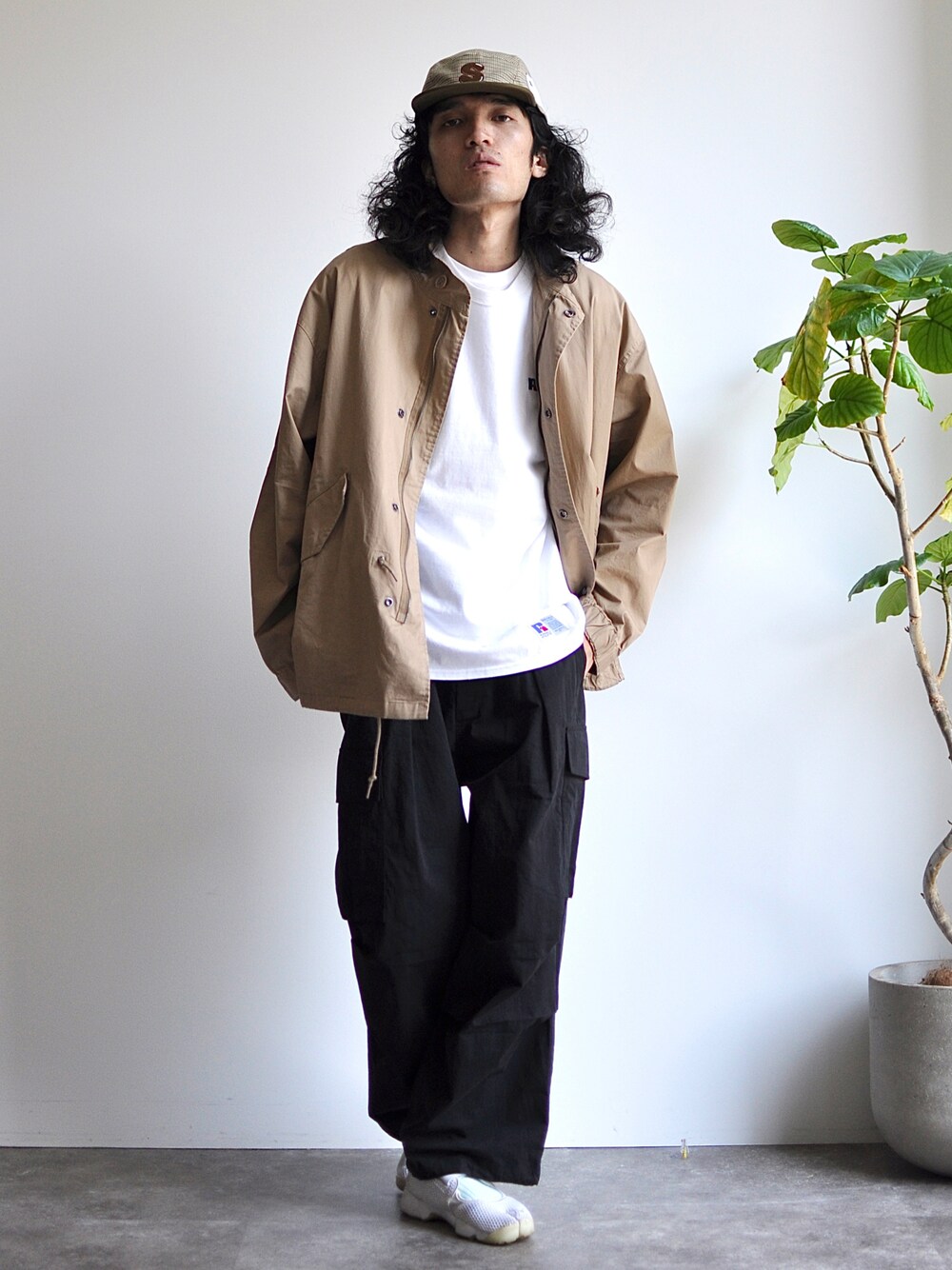 ホワイト系のTシャツ/カットソー、ベージュ系のモッズコート、ブラック系のカーゴパンツを着用したメンズの春コーディネートの1枚目の写真
