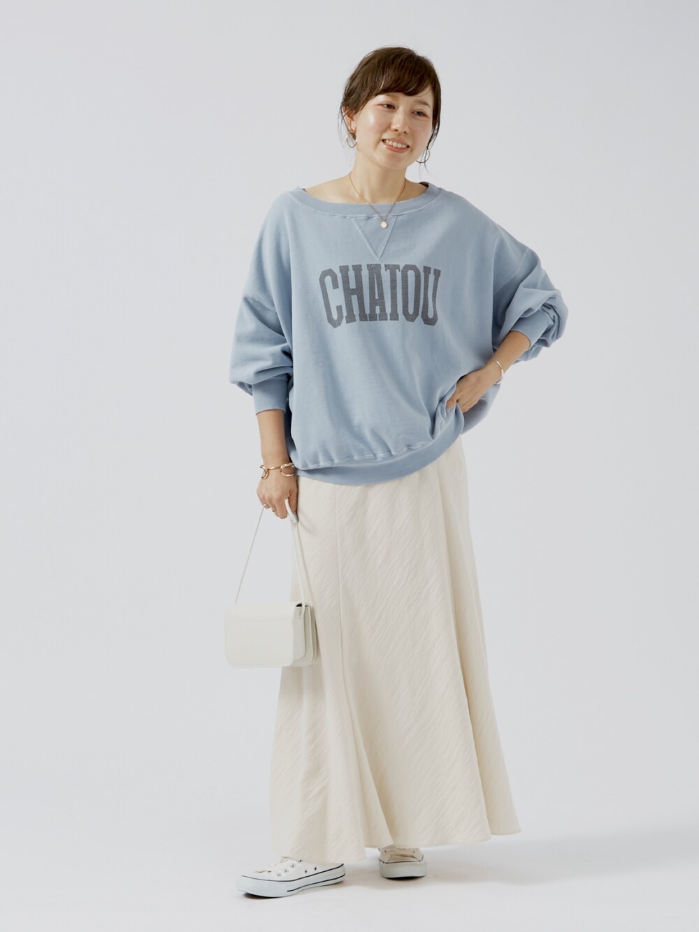 ブルー系のスウェット、ホワイト系のショルダーバッグを着用したレディースの夏コーディネートの1枚目の写真