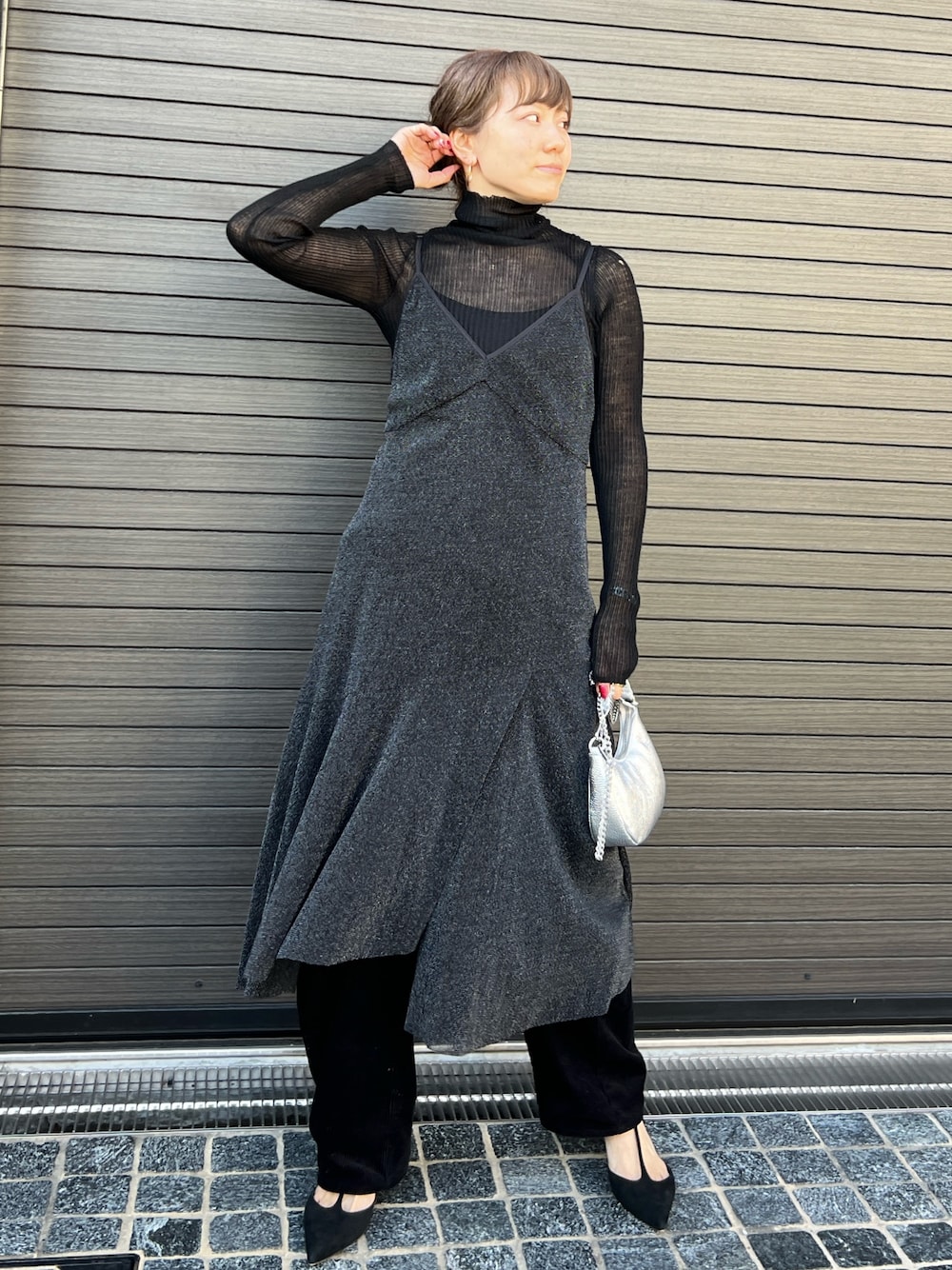 ブラック系のワンピース、ブラック系のニット/セーター、シルバー系のショルダーバッグを着用したレディースの秋コーディネートの1枚目の写真