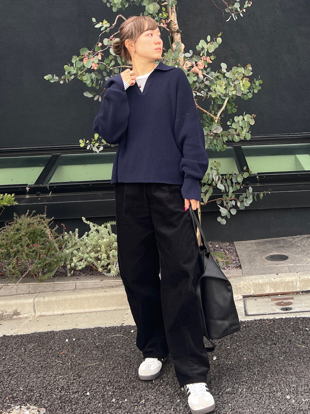 ブルー系のニット/セーター、ホワイト系のスニーカー、ブラック系のトートバッグを着用したレディースの冬コーディネートの1枚目の写真