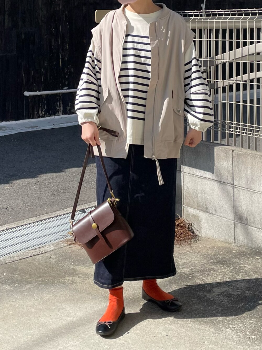 ブラウン系のショルダーバッグ、ブルー系のTシャツ/カットソー、ブルー系のデニムスカートを着用したレディースの春コーディネートの1枚目の写真