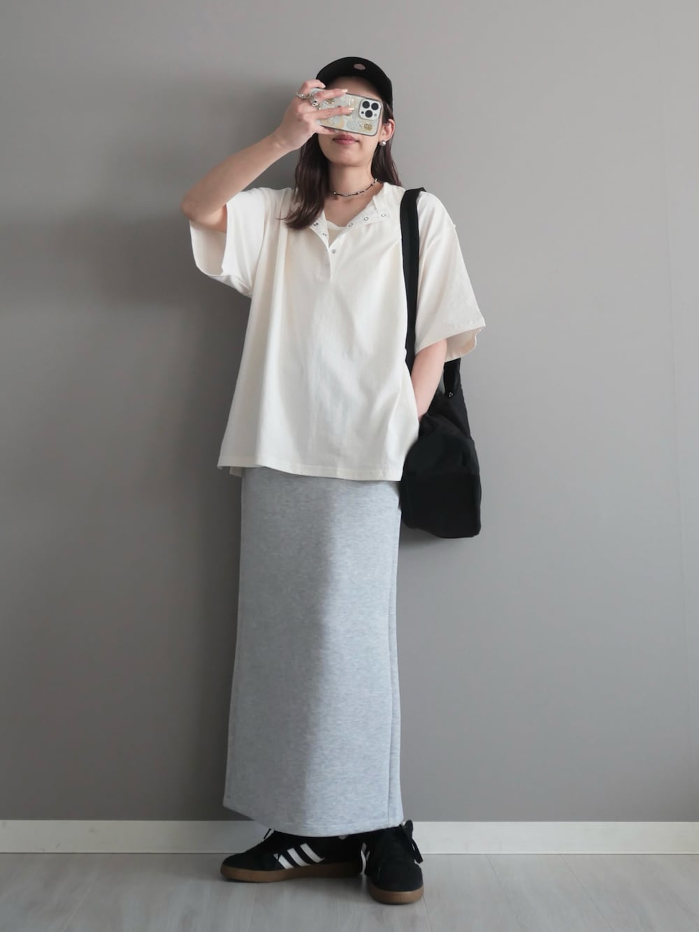 ブラック系のショルダーバッグ、ブラック系のスニーカー、シルバー系のネックレスを着用したレディースの春コーディネートの1枚目の写真