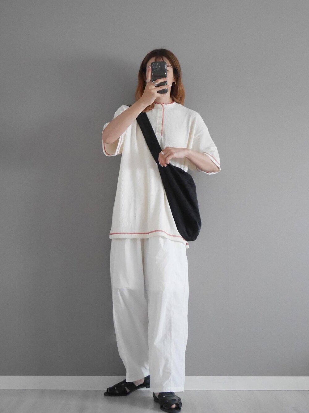 ホワイト系のTシャツ/カットソー、ホワイト系のその他パンツ、ブラック系のサンダルを着用したレディースの春コーディネートの1枚目の写真