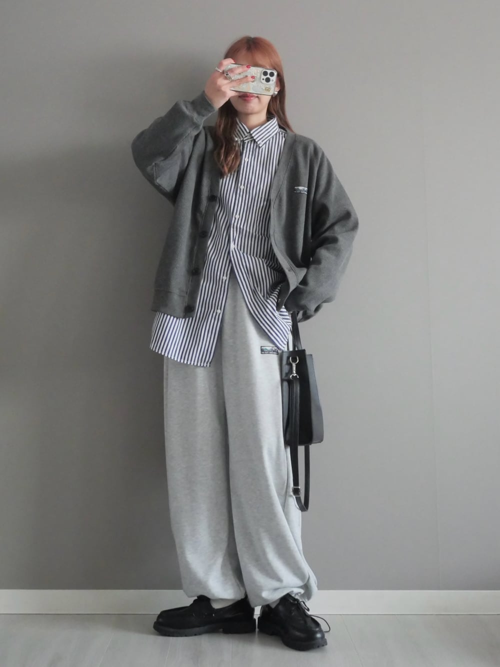 グレー系のカーディガン/ボレロ、グレー系のスウェットパンツ、ブラック系のショルダーバッグを着用したレディースの冬コーディネートの1枚目の写真