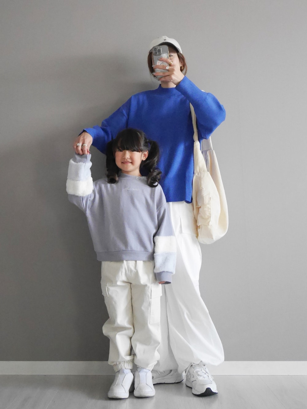 ブルー系のニット/セーター、ホワイト系のカーゴパンツ、ホワイト系のショルダーバッグを着用したレディースの秋コーディネートの1枚目の写真