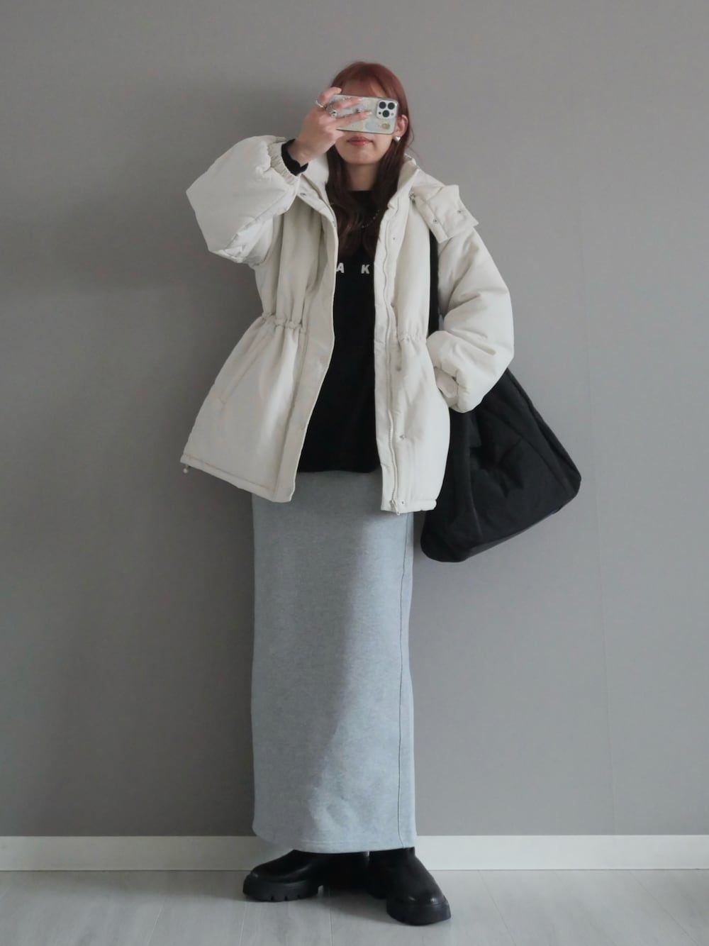 ホワイト系のダウンジャケット/コート、ブラック系のブーツ、ブラック系のTシャツ/カットソーを着用したレディースの冬コーディネートの1枚目の写真