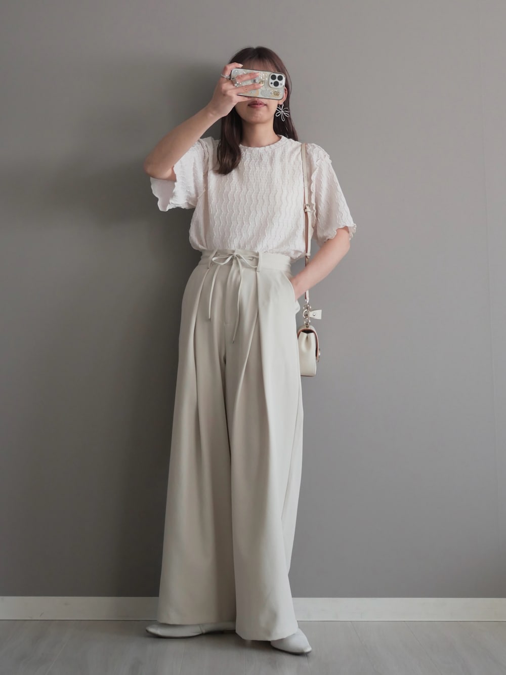 ホワイト系のスラックス、ホワイト系のパンプス、ホワイト系のTシャツ/カットソーを着用したレディースの春コーディネートの1枚目の写真