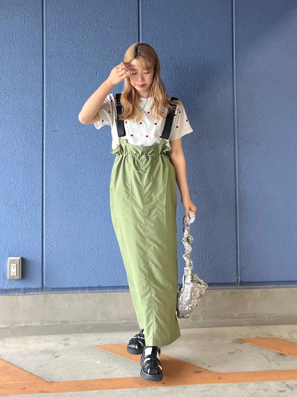 グリーン系のジャンパースカート、ベージュ系のTシャツ/カットソー、シルバー系のハンドバッグを着用したレディースの夏コーディネートの1枚目の写真