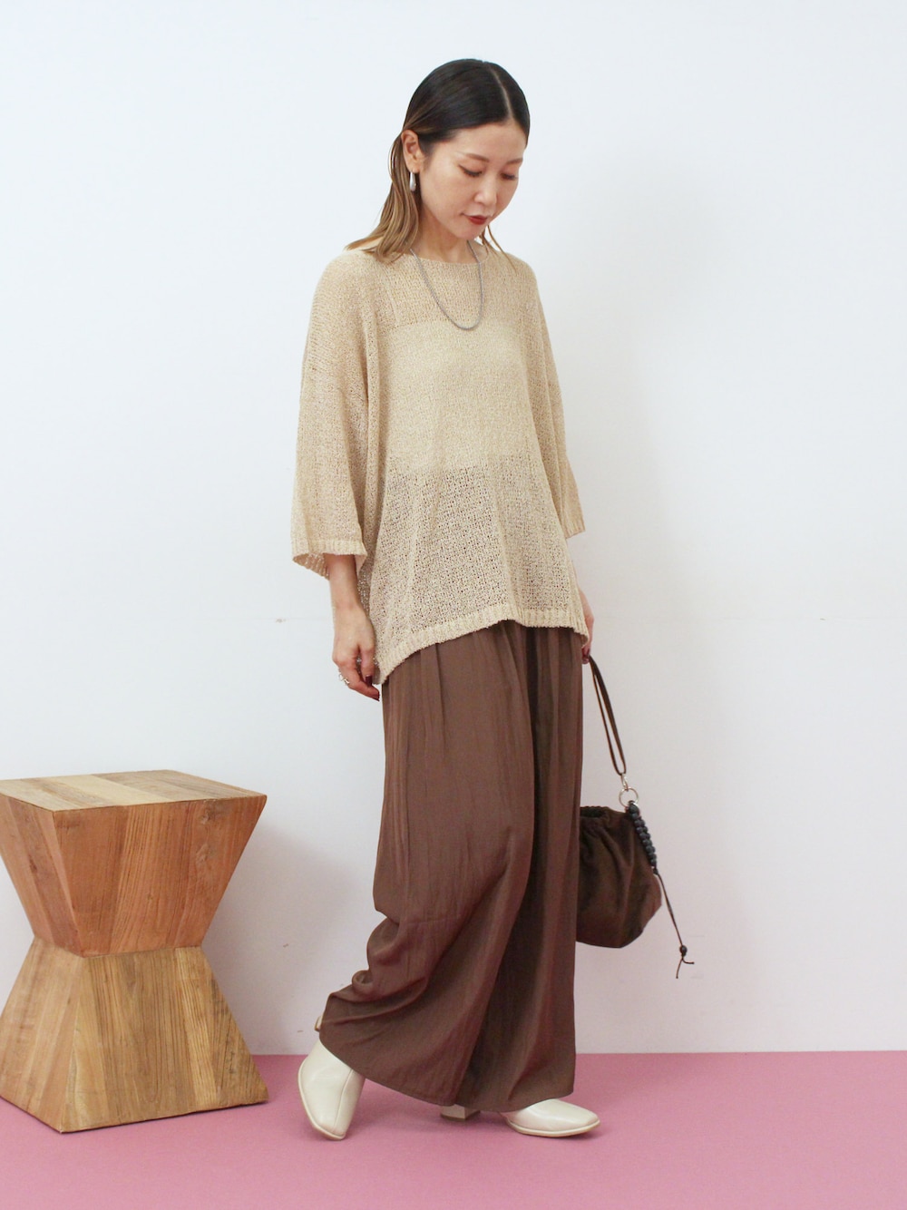 ベージュ系のニット/セーター、ブラウン系のその他パンツ、ブラウン系のハンドバッグを着用したレディースの秋コーディネートの1枚目の写真