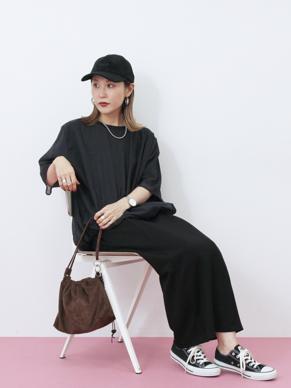 ブラック系のTシャツ/カットソー、ブラック系のスカート、ブラウン系のハンドバッグを着用したレディースの秋コーディネートの1枚目の写真