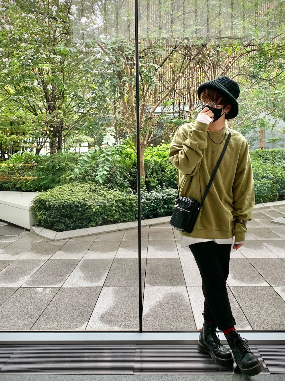 ブラック系のブーツ、グリーン系のスウェット、ブラック系のショルダーバッグを着用したメンズの秋コーディネートの1枚目の写真