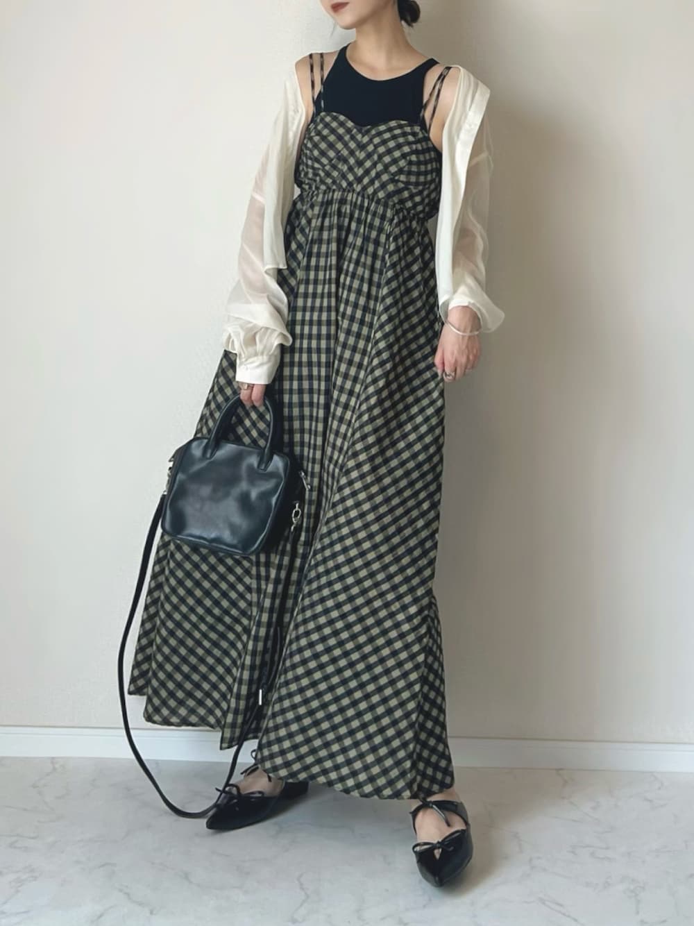 グリーン系のワンピース、ブラック系のサンダル、ブラック系のタンクトップを着用したレディースの春コーディネートの1枚目の写真