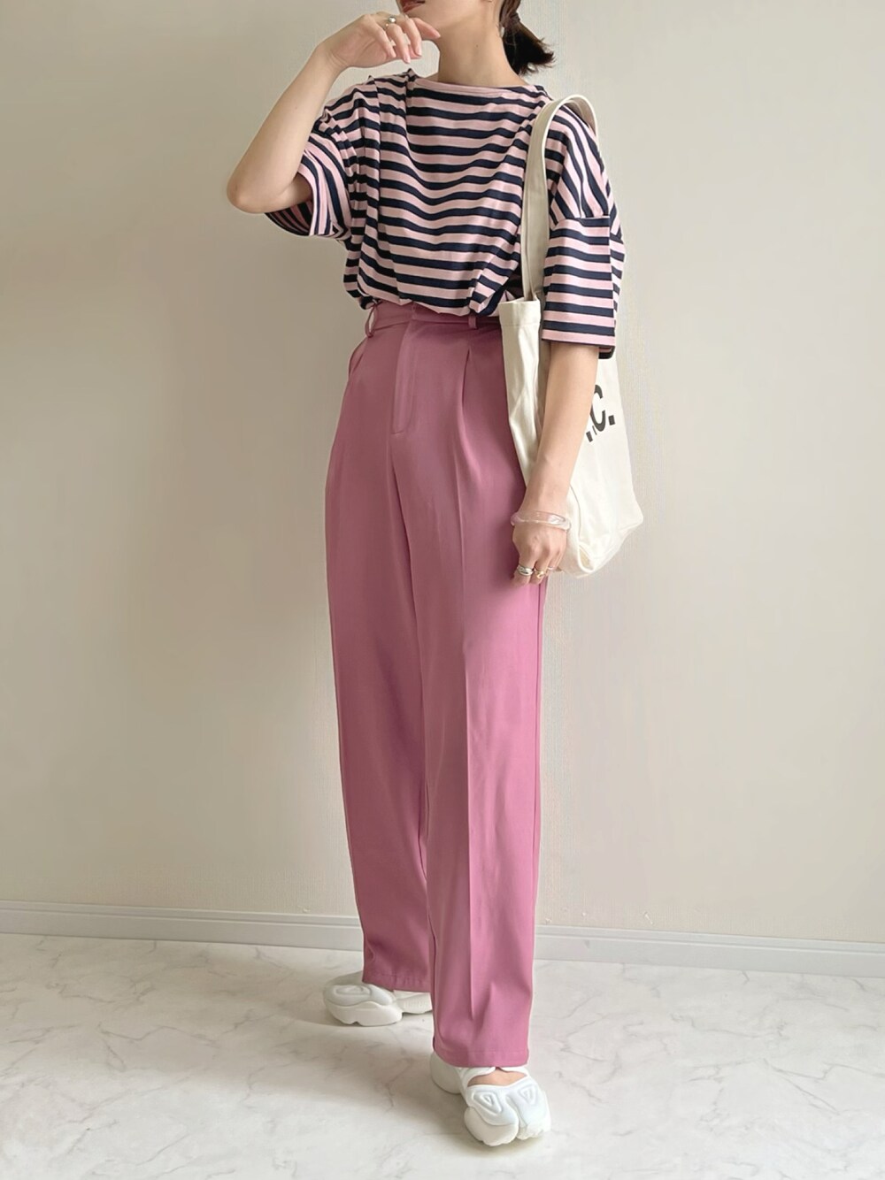 ピンク系のTシャツ/カットソー、ピンク系のスラックス、ホワイト系のスニーカーを着用したレディースの春コーディネートの1枚目の写真