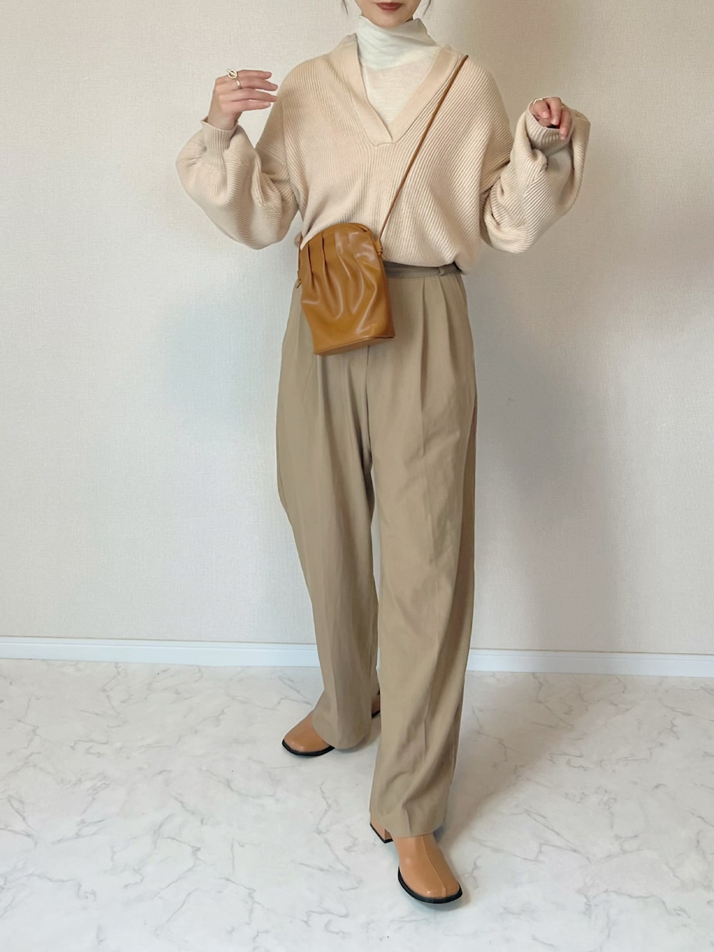 ホワイト系のニット/セーター、イエロー系のショルダーバッグ、ブラウン系のブーツを着用したレディースの秋コーディネートの1枚目の写真