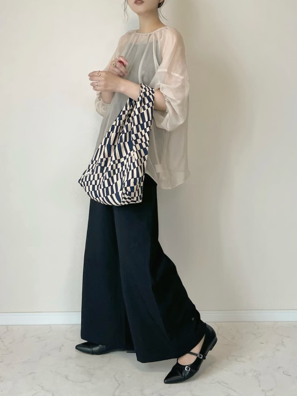 ベージュ系のシャツ/ブラウス、ブラック系のその他パンツ、ブルー系のトートバッグを着用したレディースの春コーディネートの1枚目の写真