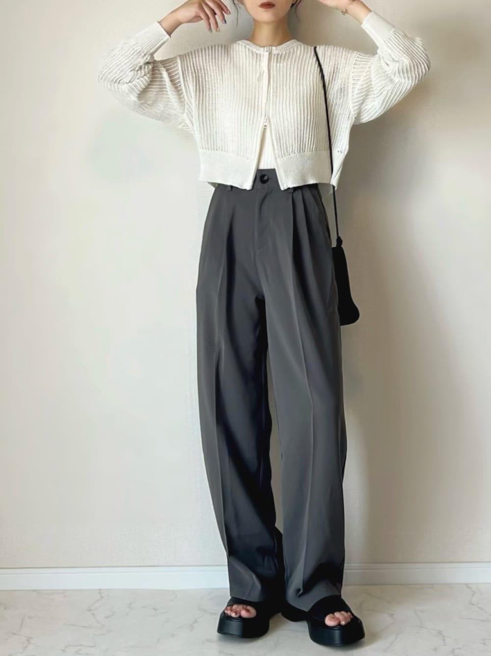 ホワイト系のカーディガン/ボレロ、グレー系のスラックス、ブラック系のサンダルを着用したレディースの夏コーディネートの1枚目の写真