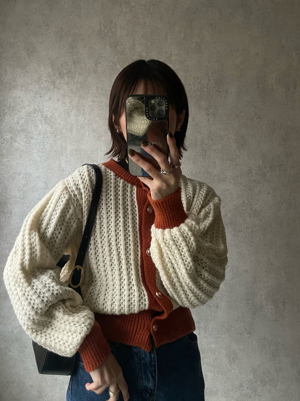 ホワイト系のカーディガン/ボレロ、ブルー系のデニムパンツを着用したレディースの冬コーディネートの1枚目の写真