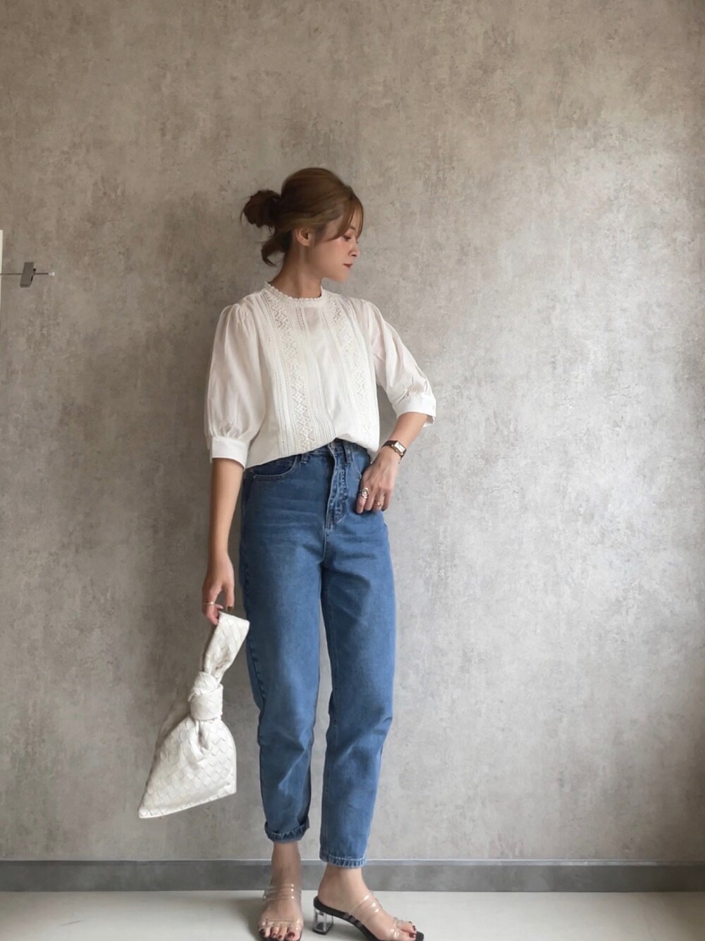 ブルー系のデニムパンツ、ホワイト系のシャツ/ブラウス、ホワイト系のバッグを着用したレディースの夏コーディネートの1枚目の写真