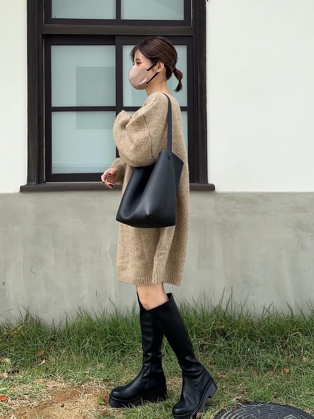 ベージュ系のワンピース、ブラック系のブーツを着用したレディースの秋コーディネートの1枚目の写真