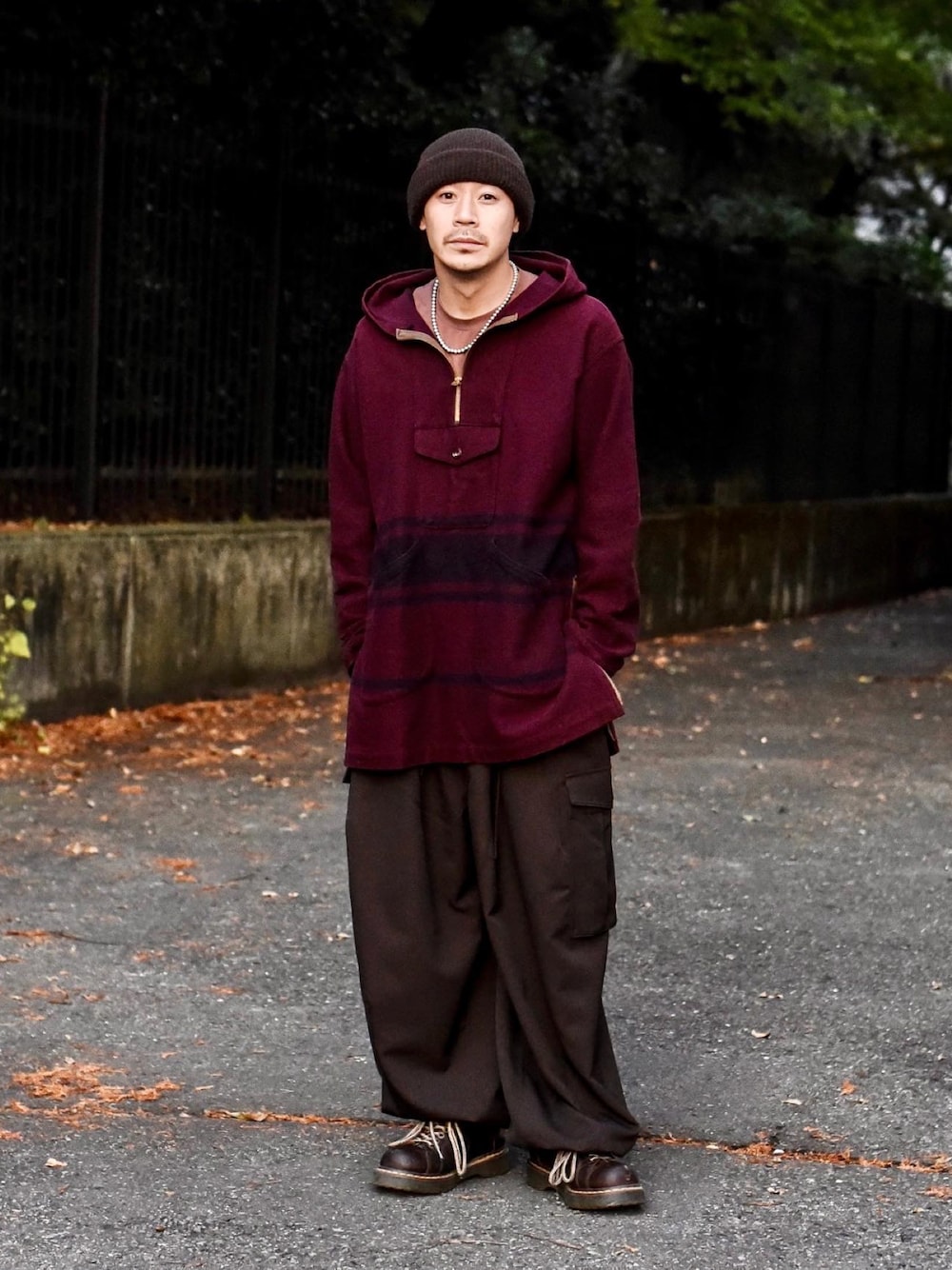 パープル系のマウンテンパーカー、ブラウン系のカーゴパンツを着用したメンズの秋コーディネートの1枚目の写真