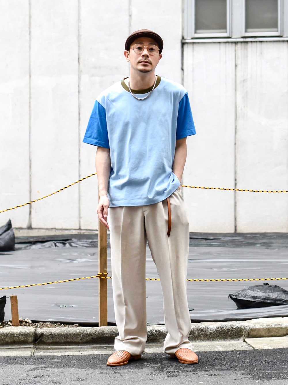 ホワイト系のスラックス、ブルー系のTシャツ/カットソー、ベージュ系のサンダルを着用したメンズの春コーディネートの1枚目の写真