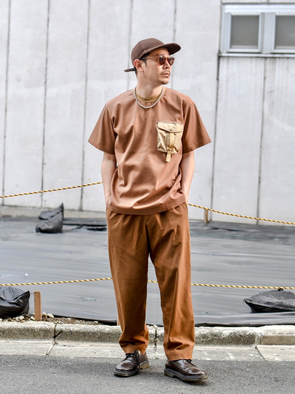 ブラウン系のTシャツ/カットソー、ブラウン系のパンツ、ブラウン系のブーツを着用したメンズの夏コーディネートの1枚目の写真