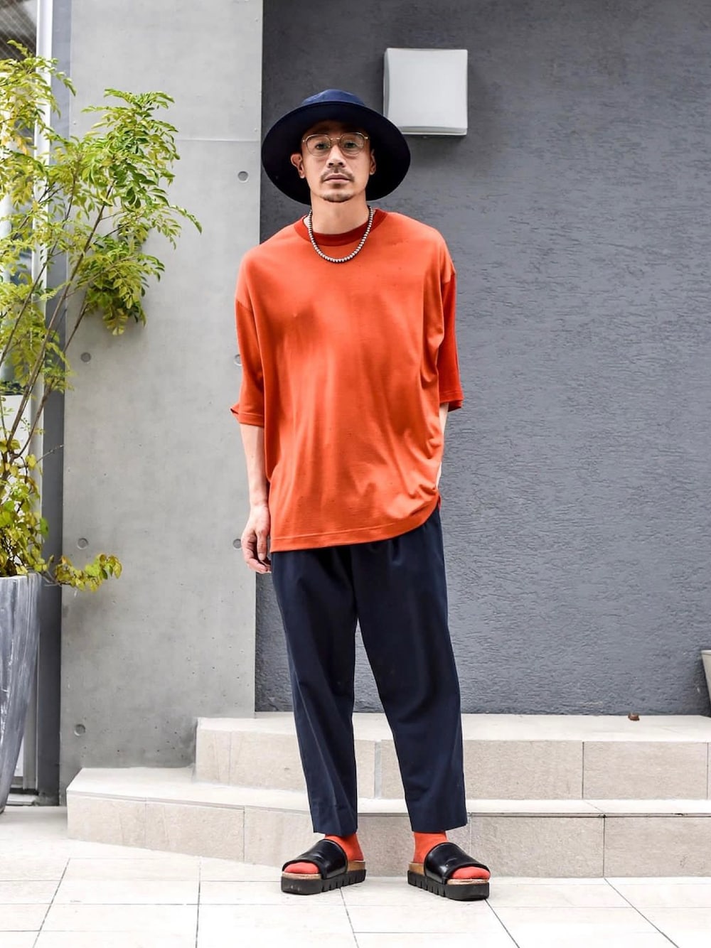 オレンジ系のTシャツ/カットソーを着用したメンズの夏コーディネートの1枚目の写真