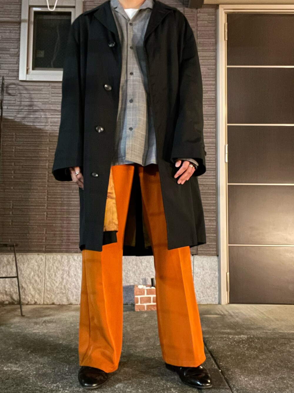 ブラック系のトレンチコート、グレー系のシャツ/ブラウス、ホワイト系のTシャツ/カットソーを着用したメンズの春コーディネートの1枚目の写真