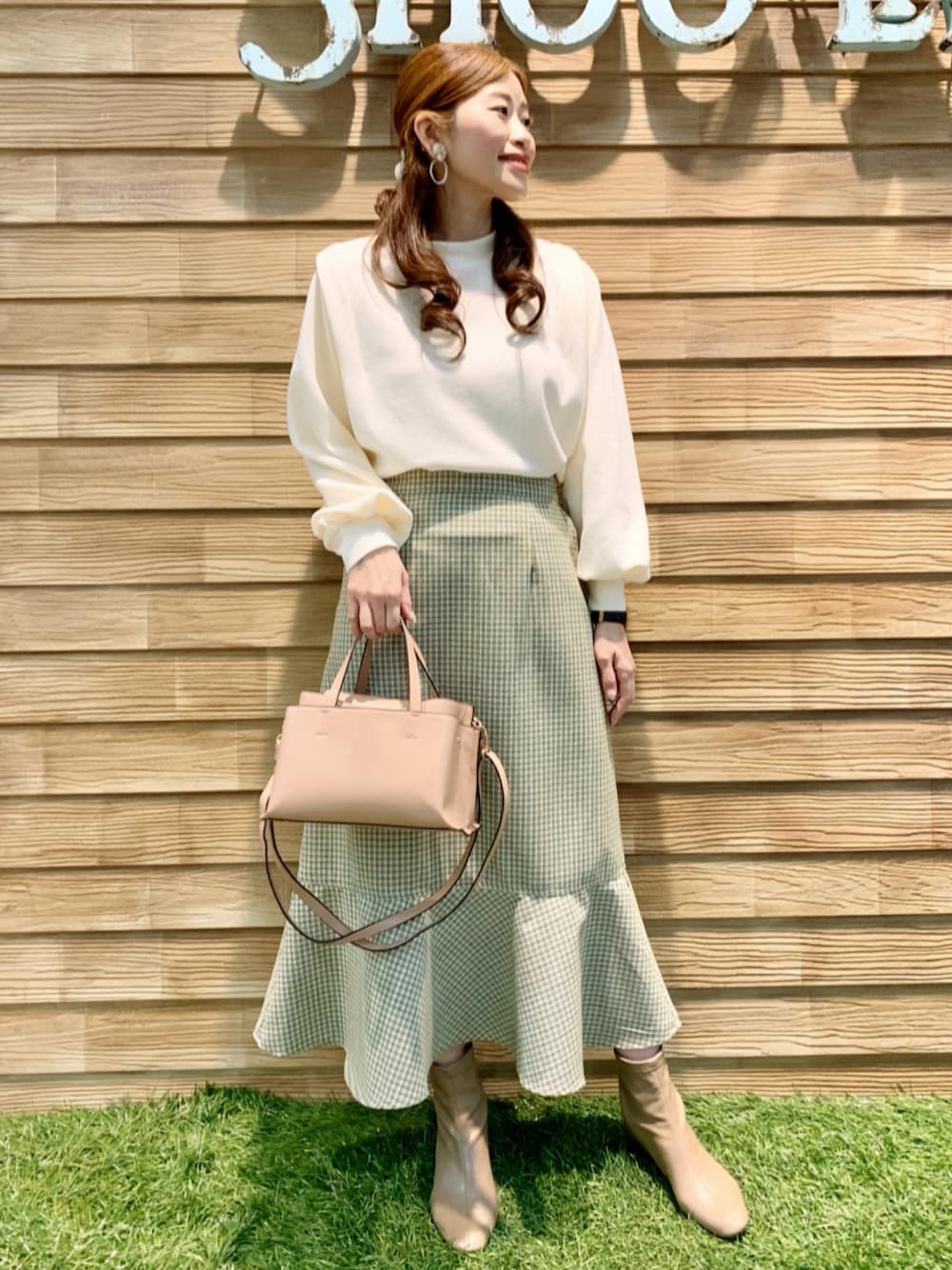 ホワイト系のTシャツ/カットソー、グリーン系のスカート、ピンク系のショルダーバッグを着用したレディースの冬コーディネートの1枚目の写真