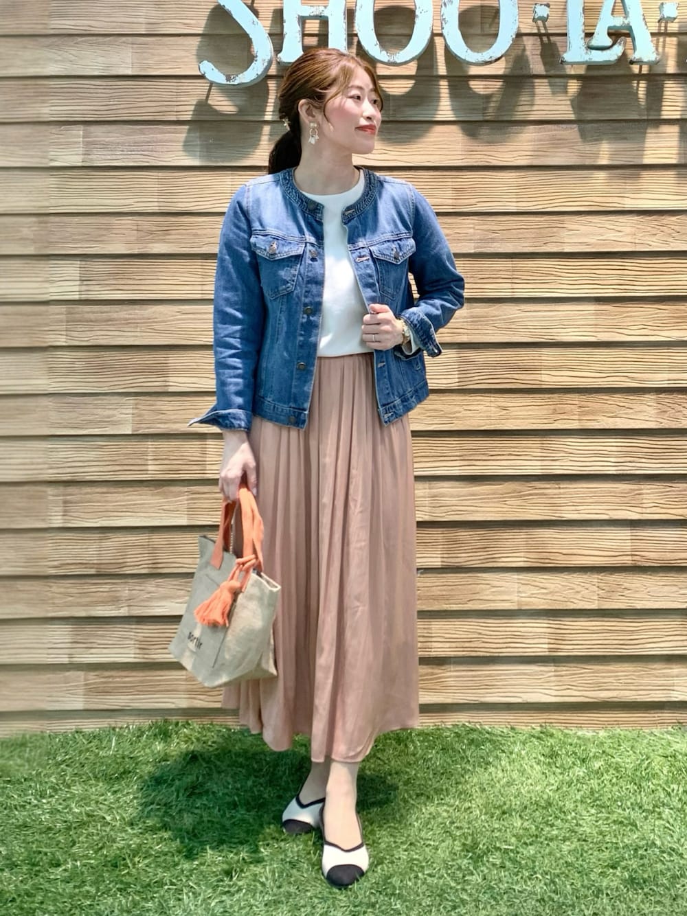 ブルー系のデニムジャケット、ベージュ系のTシャツ/カットソー、オレンジ系のスカートを着用したレディースの春コーディネートの1枚目の写真