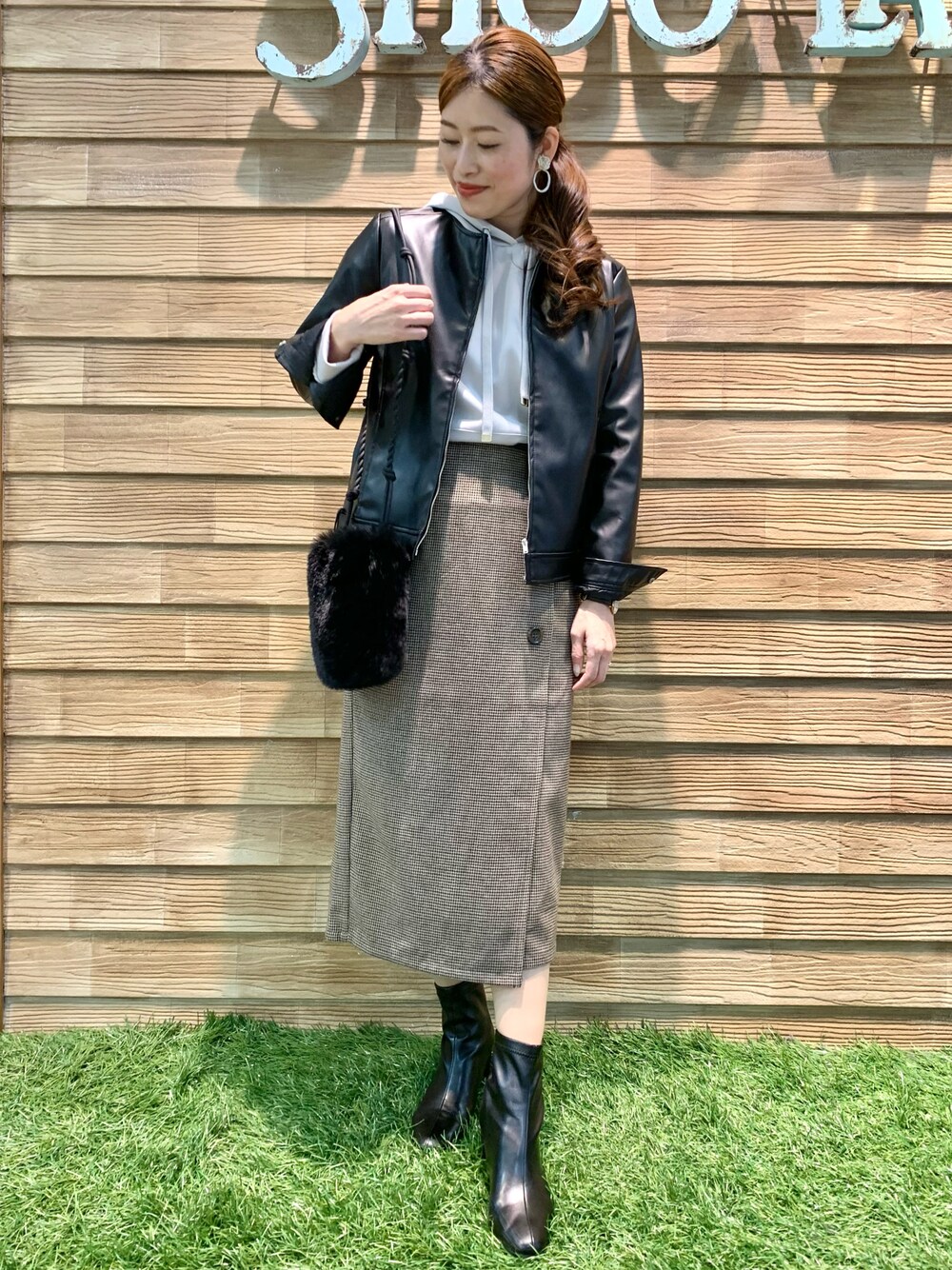 ブラック系のライダースジャケット、グレー系のパーカー、ベージュ系のスカートを着用したレディースの秋コーディネートの1枚目の写真