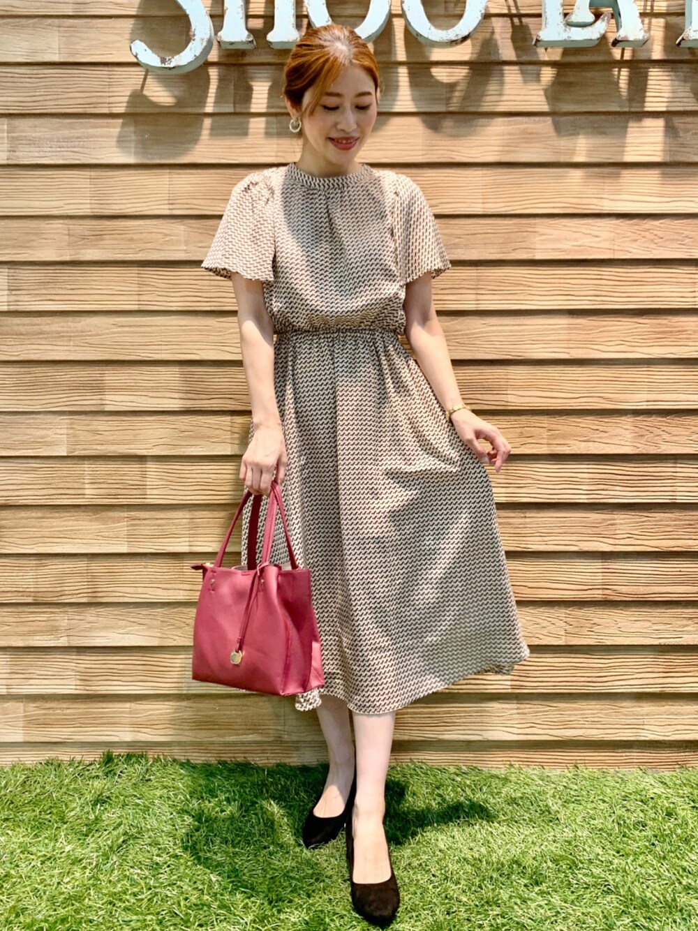 ベージュ系のワンピース、ピンク系のトートバッグ、ブラック系のパンプスを着用したレディースの秋コーディネートの1枚目の写真