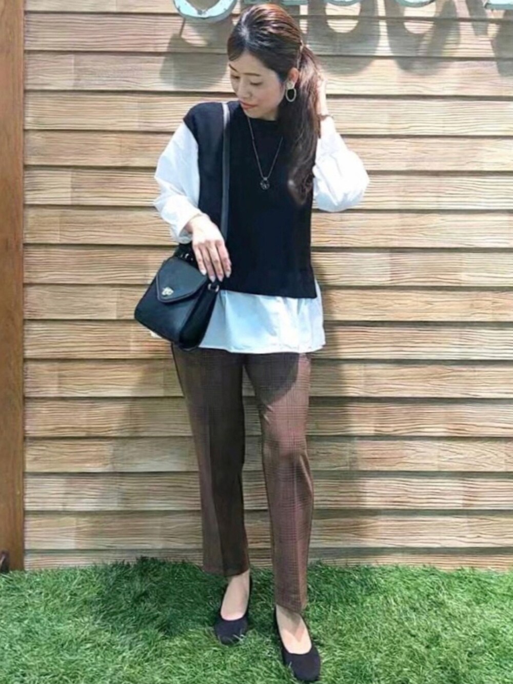 ブラック系のニット/セーター、ブラウン系のその他パンツ、ブラック系のショルダーバッグを着用したレディースの秋コーディネートの1枚目の写真