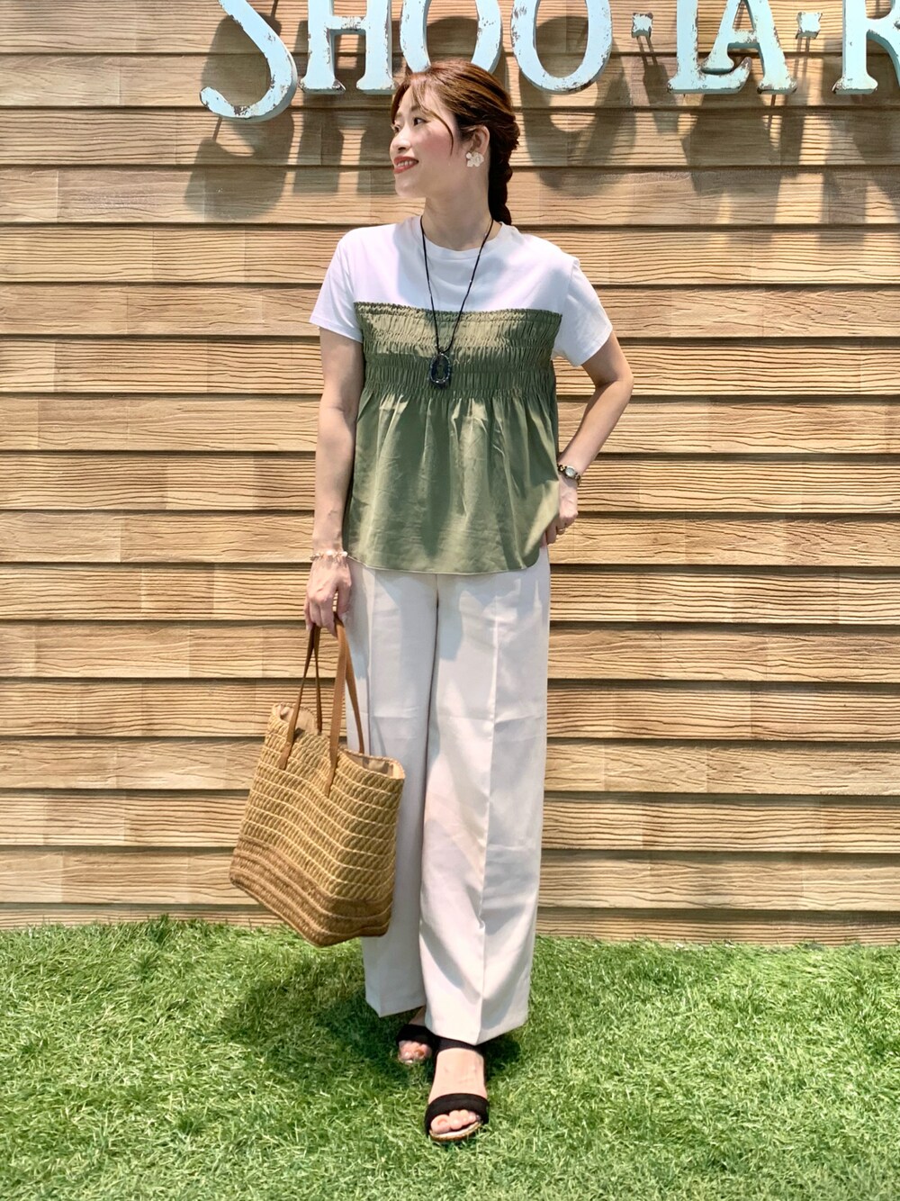 グリーン系のTシャツ/カットソー、ベージュ系のその他パンツ、ブラウン系のトートバッグを着用したレディースの秋コーディネートの1枚目の写真