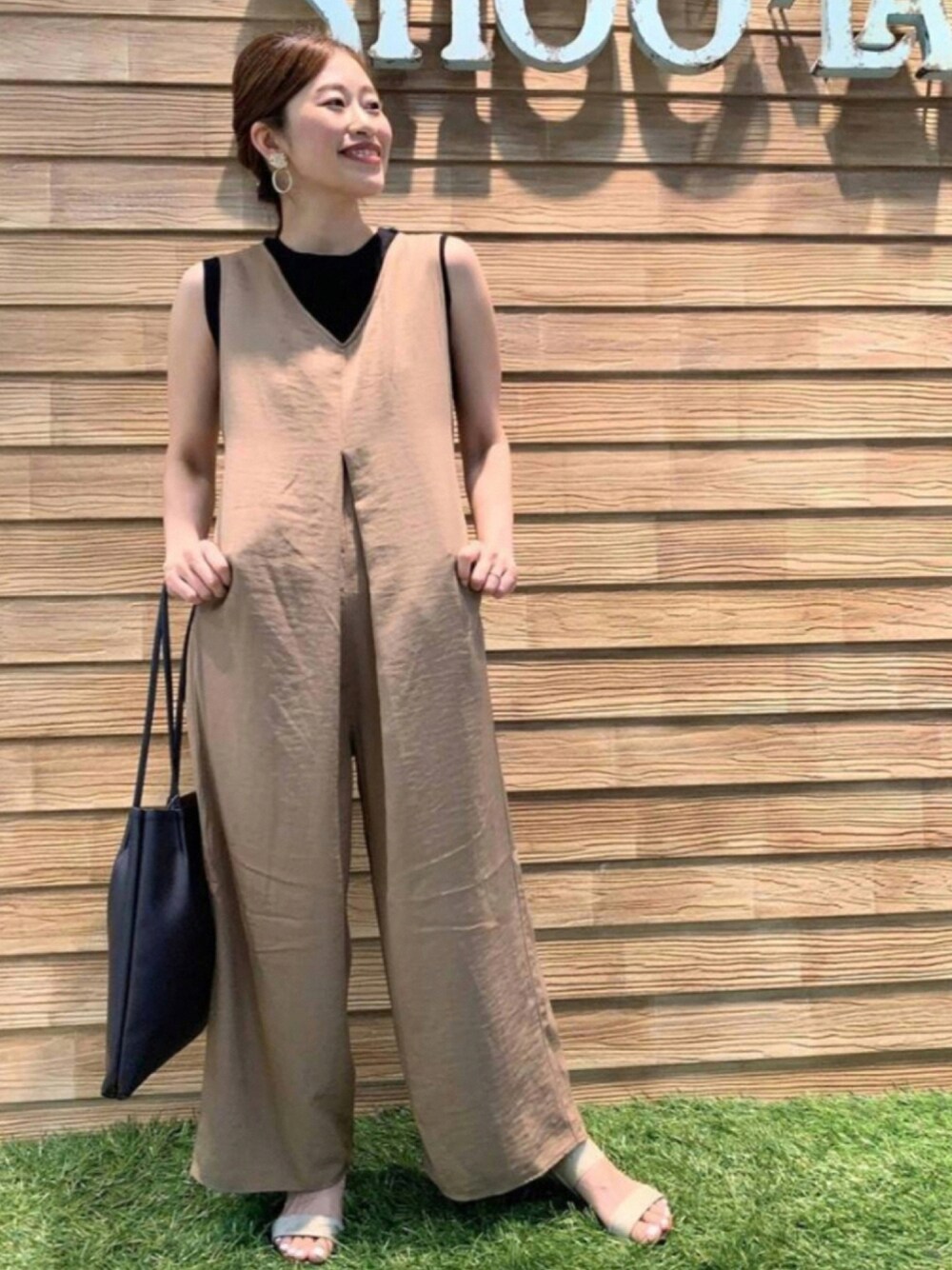 ブラウン系のサロペット/オーバーオール、ブラック系のタンクトップ、ブラック系のトートバッグを着用したレディースの秋コーディネートの1枚目の写真