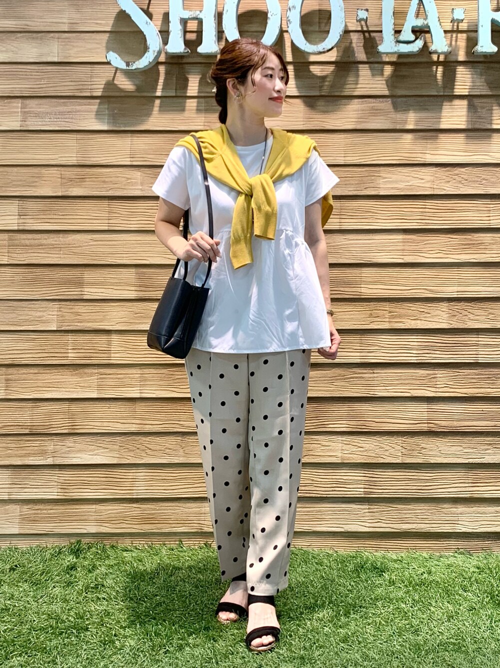 イエロー系のカーディガン/ボレロ、ホワイト系のTシャツ/カットソー、ベージュ系のその他パンツを着用したレディースの秋コーディネートの1枚目の写真