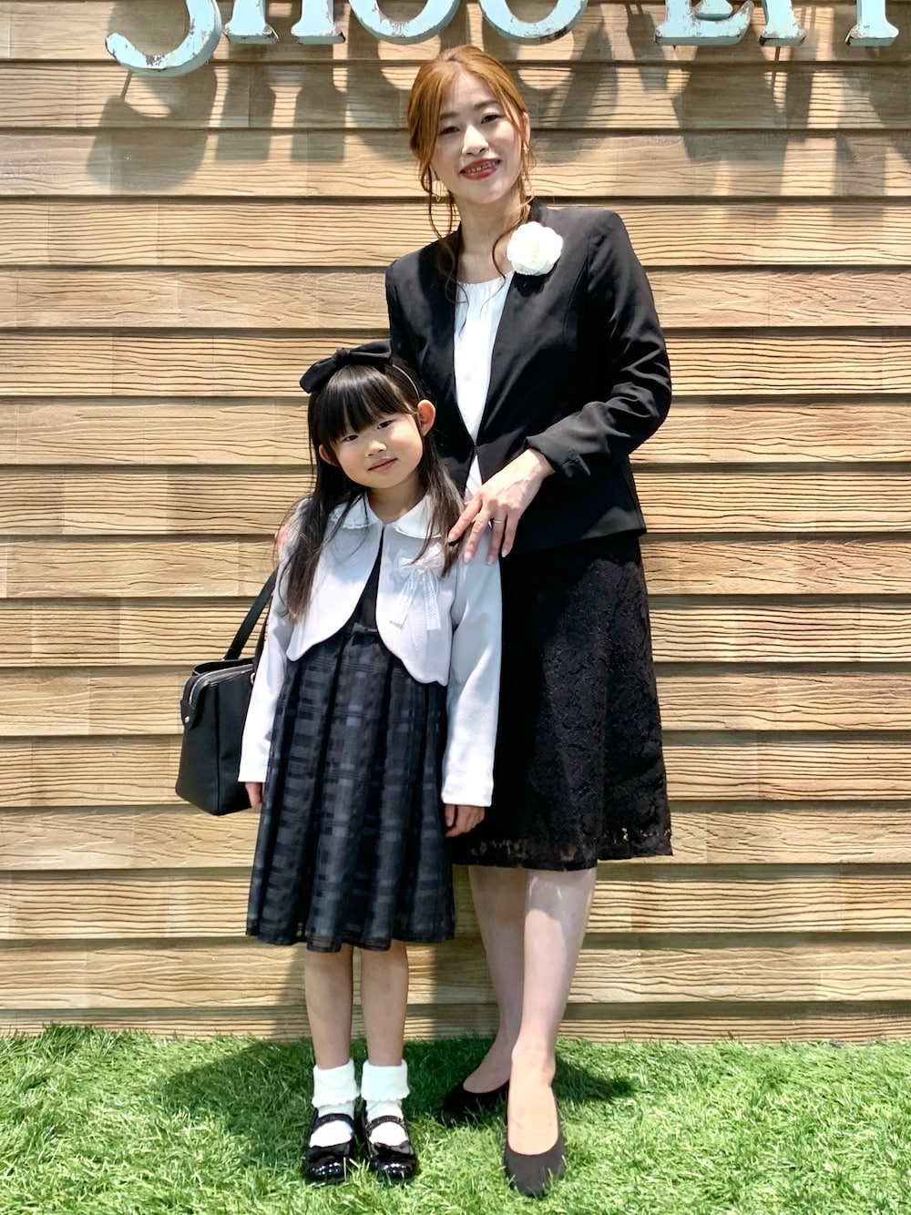 ブラック系のノーカラージャケット、ホワイト系のシャツ/ブラウス、ブラック系のスカートを着用したレディースの冬コーディネートの1枚目の写真