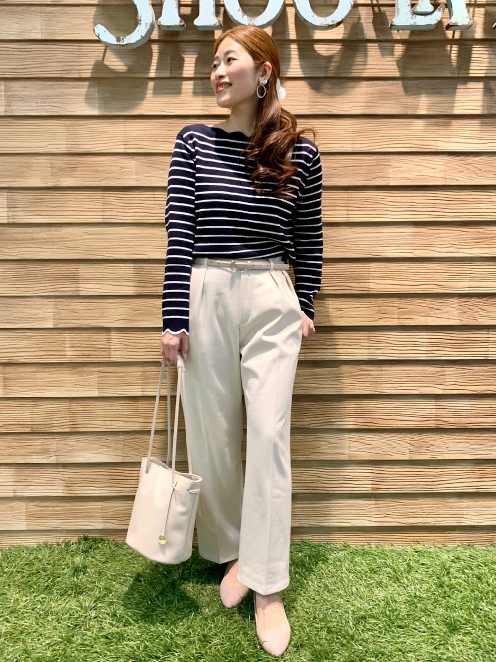 ブルー系のニット/セーター、ホワイト系のその他パンツ、ホワイト系のトートバッグを着用したレディースの春コーディネートの1枚目の写真