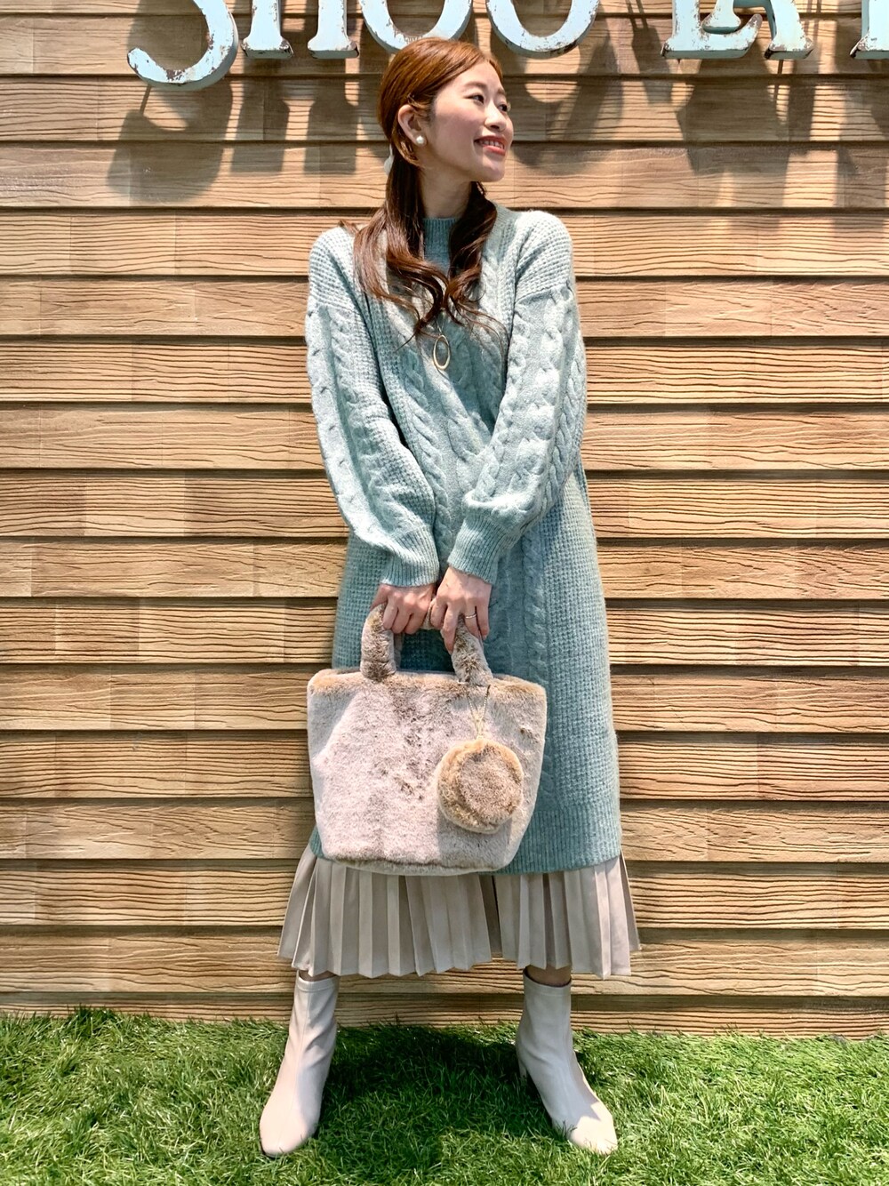 グリーン系のワンピース、ベージュ系のスカート、ベージュ系のトートバッグを着用したレディースの冬コーディネートの1枚目の写真