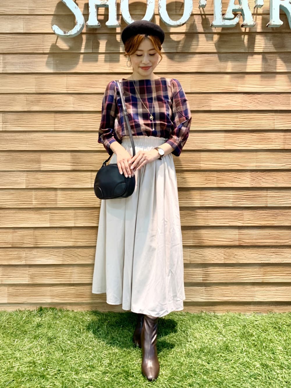 ブラウン系のシャツ/ブラウス、ホワイト系のスカート、ブラック系のショルダーバッグを着用したレディースの秋コーディネートの1枚目の写真